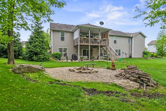 back of house with stairway, a wooden deck, a fire pit, a lawn, and a patio