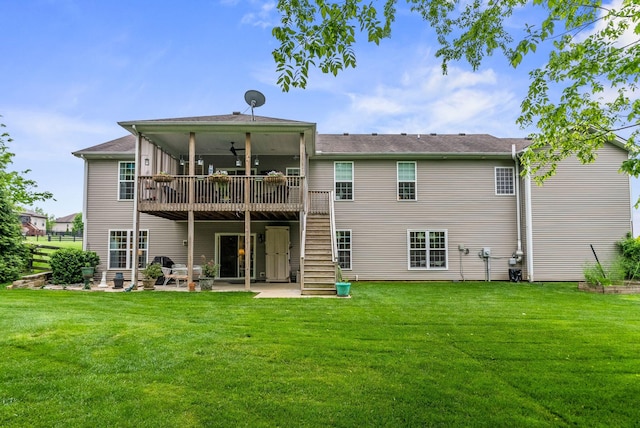 rear view of property featuring a patio area, a ceiling fan, a yard, a deck, and stairs