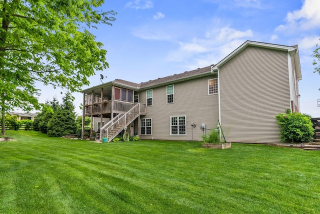 rear view of property with a sunroom, stairway, and a yard