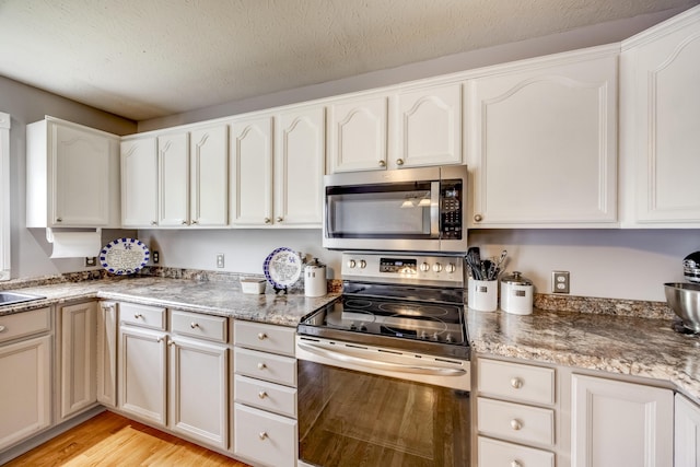 44 Gwinn Island Cir, Danville, KY 40422 - kitchen with stainless steel appliances, light wood-style flooring, and white cabinetry
