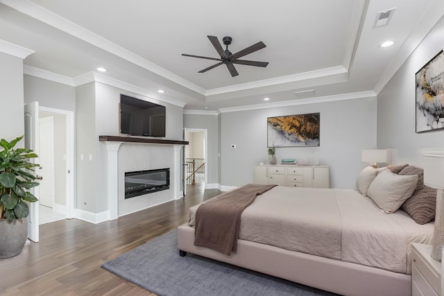 2269 Savannah Ln, Lexington, KY 40513 - bedroom featuring a raised ceiling, wood finished floors, recessed lighting, ornamental molding, and a glass covered fireplace