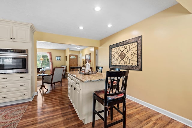 256 Michael Blvd, Frankfort, KY 40601 - kitchen featuring oven, light stone counters, dark wood-style flooring, a center island, and white cabinets