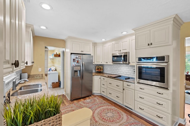 256 Michael Blvd, Frankfort, KY 40601 - kitchen featuring appliances with stainless steel finishes, a sink, light stone countertops, backsplash, and light wood-style floors