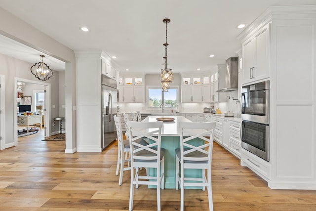 502 W Brannon Rd, Nicholasville, KY 40356 - kitchen featuring wall chimney range hood, appliances with stainless steel finishes, white cabinetry, a sink, and light countertops