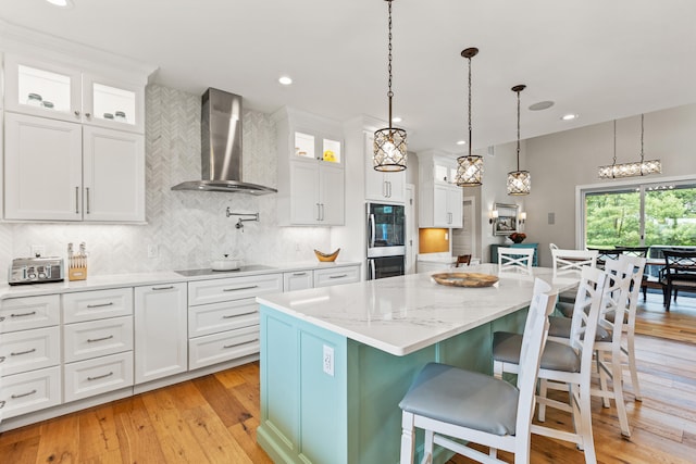 502 W Brannon Rd, Nicholasville, KY 40356 - kitchen featuring wall chimney exhaust hood, double oven, a kitchen island, tasteful backsplash, and white cabinetry