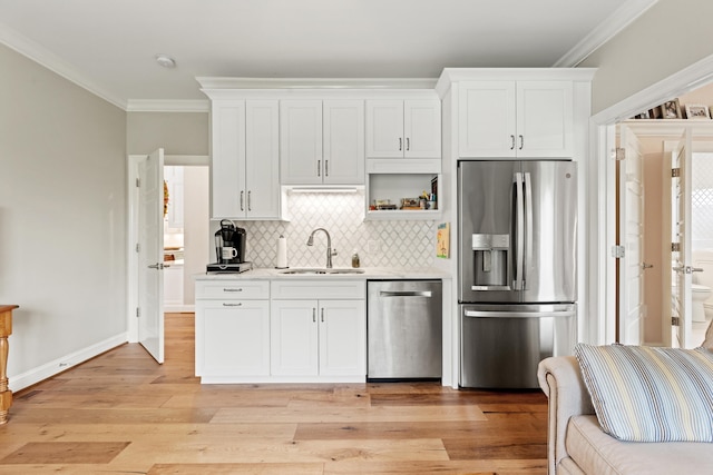 502 W Brannon Rd, Nicholasville, KY 40356 - kitchen featuring appliances with stainless steel finishes, a sink, crown molding, decorative backsplash, and light wood finished floors