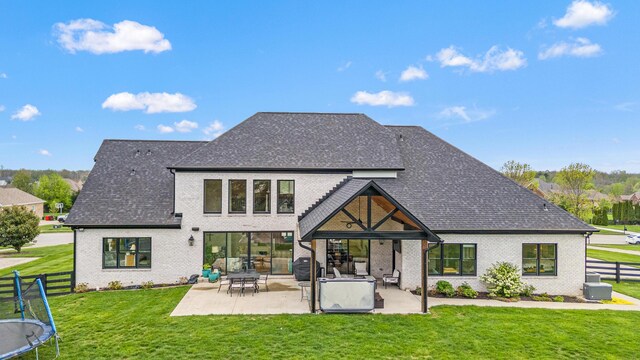 502 W Brannon Rd, Nicholasville, KY 40356 - rear view of house featuring a patio area, brick siding, a trampoline, and a shingled roof