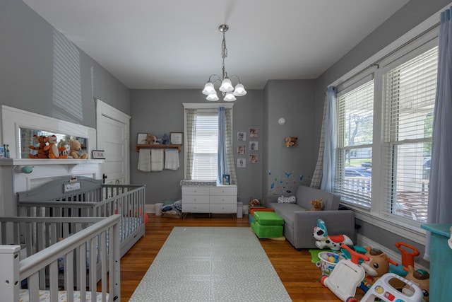 playroom featuring wood finished floors, baseboards, and a chandelier