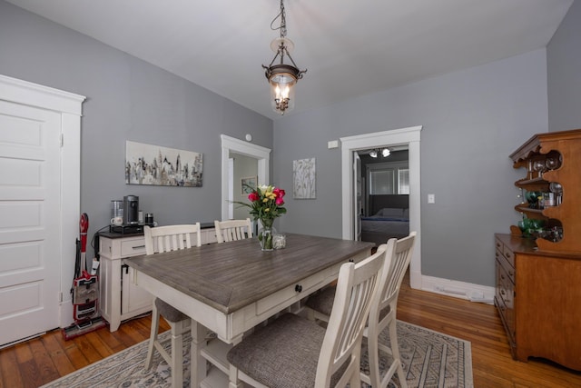 dining space with hardwood / wood-style flooring and baseboards
