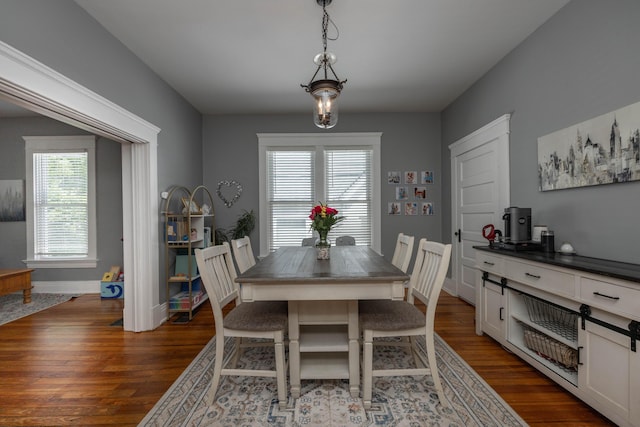 dining area featuring dark wood finished floors, plenty of natural light, and baseboards