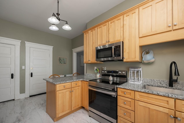 kitchen featuring appliances with stainless steel finishes, light marble finish flooring, a sink, a peninsula, and light brown cabinetry