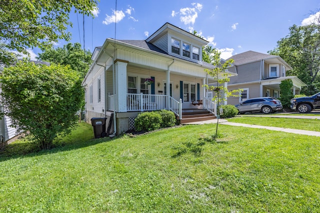 bungalow featuring covered porch and a front lawn