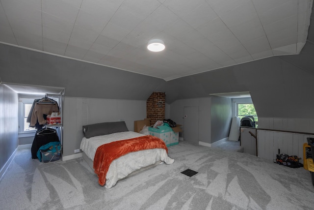 bedroom with carpet floors and lofted ceiling