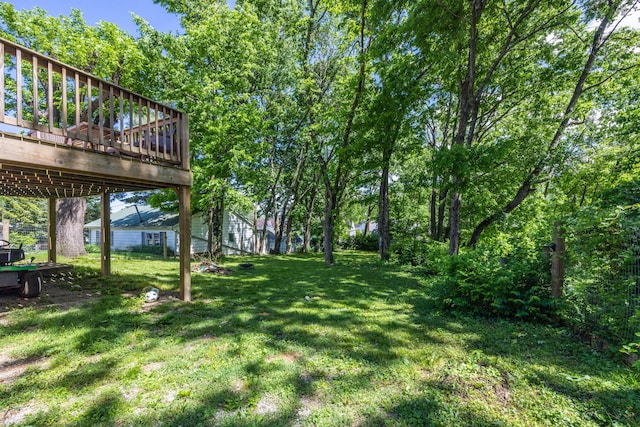 view of green lawn with a deck