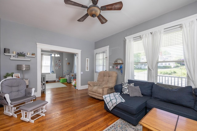 living room with wood finished floors, ceiling fan, and baseboards