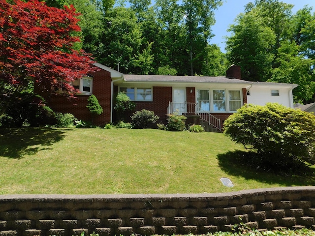 184 Meadow Dr, Harlan, KY 40831 - view of front of house featuring a front lawn, brick siding, and a chimney