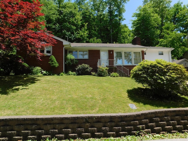 184 Meadow Dr, Harlan, KY 40831 - ranch-style home with a front lawn, a chimney, and brick siding