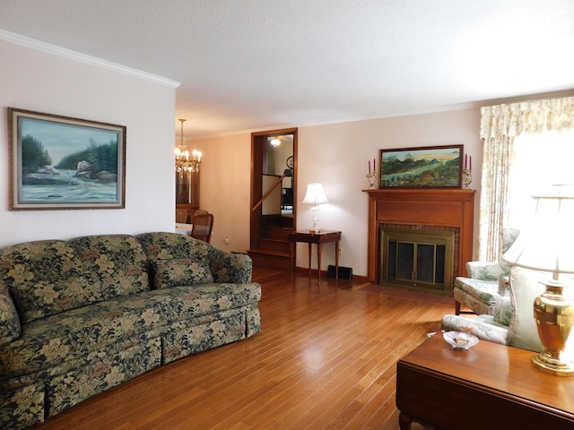 184 Meadow Dr, Harlan, KY 40831 - living area featuring ornamental molding, a chandelier, wood finished floors, and a fireplace with flush hearth