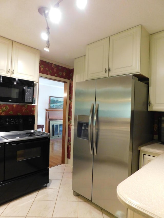 184 Meadow Dr, Harlan, KY 40831 - kitchen featuring black appliances, white cabinetry, light tile patterned flooring, wallpapered walls, and light countertops