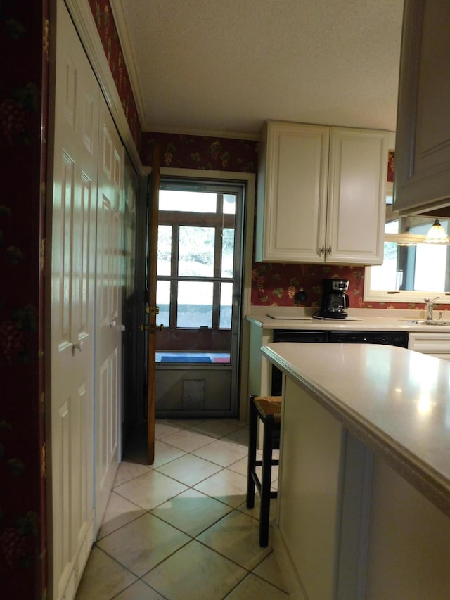 184 Meadow Dr, Harlan, KY 40831 - kitchen with light countertops, light tile patterned flooring, a sink, crown molding, and white cabinetry