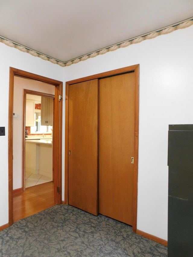 184 Meadow Dr, Harlan, KY 40831 - unfurnished bedroom featuring a closet, carpet floors, and baseboards