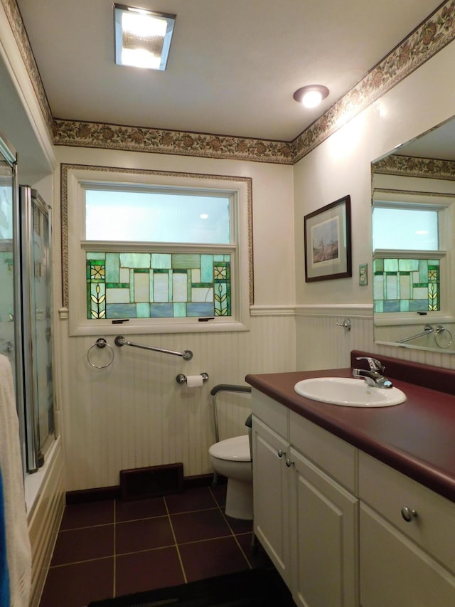 184 Meadow Dr, Harlan, KY 40831 - full bath featuring tile patterned flooring, toilet, wainscoting, vanity, and enclosed tub / shower combo
