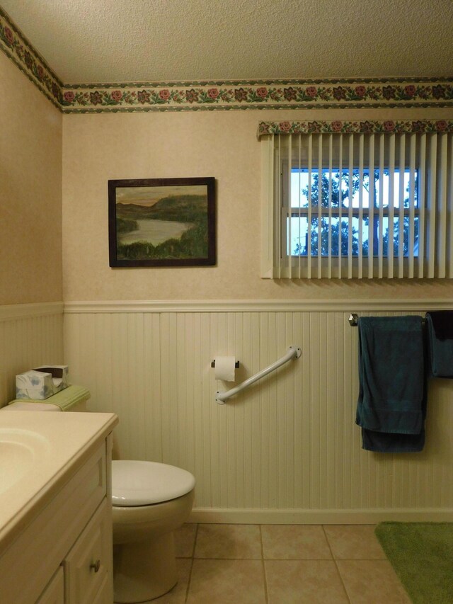 184 Meadow Dr, Harlan, KY 40831 - half bath featuring a wainscoted wall, tile patterned floors, toilet, vanity, and a textured ceiling