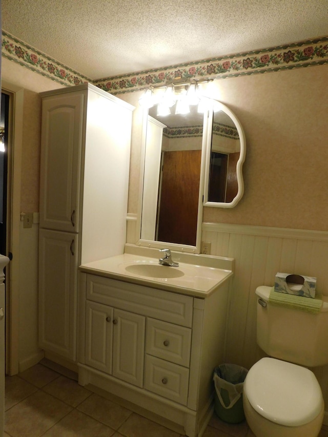 184 Meadow Dr, Harlan, KY 40831 - half bathroom with wainscoting, tile patterned flooring, vanity, a textured ceiling, and toilet