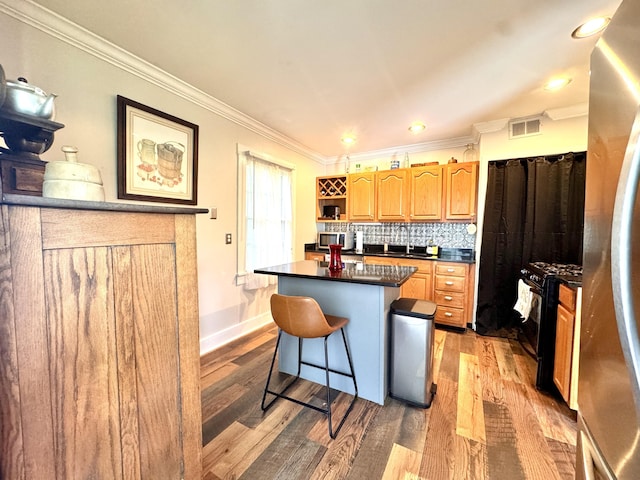 8 N Sycamore St, Mt Sterling, KY 40353 - kitchen featuring black range with gas cooktop, dark countertops, open shelves, a kitchen bar, and light wood-type flooring