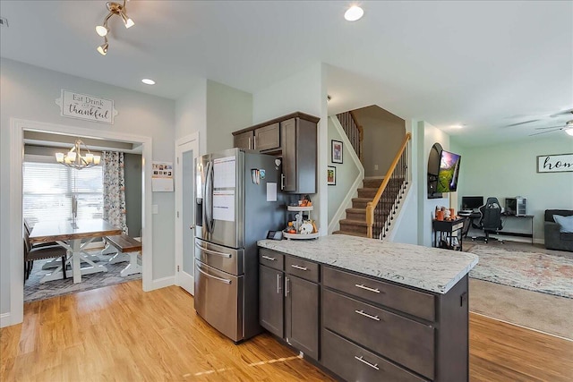 kitchen with stainless steel fridge with ice dispenser, a chandelier, dark brown cabinets, open floor plan, and light wood-style floors