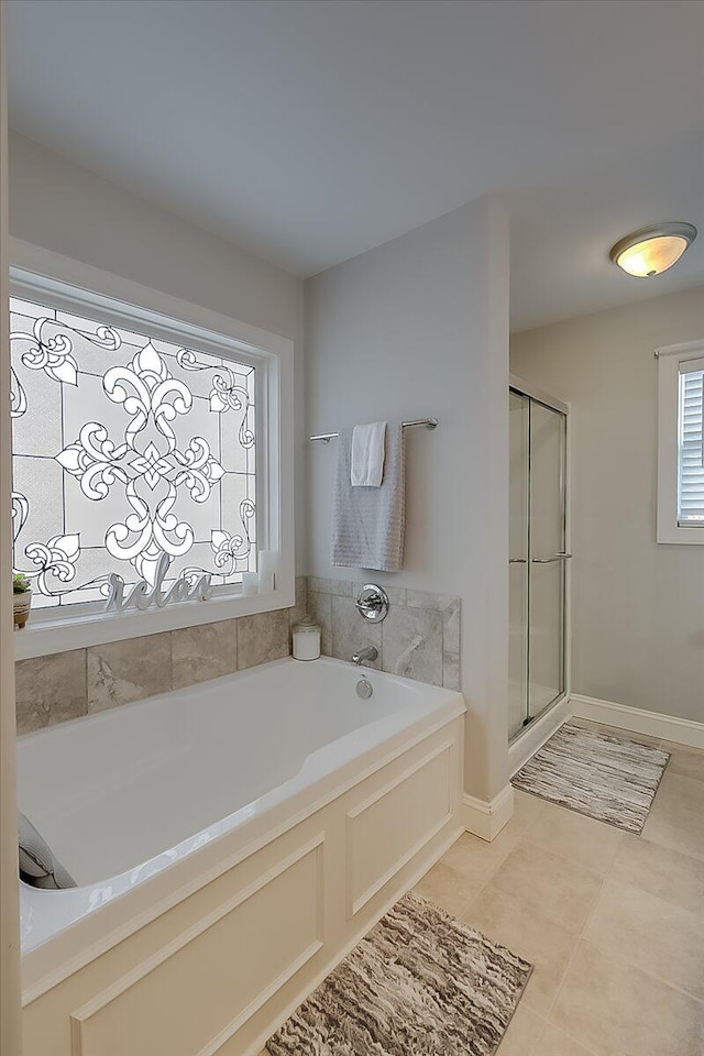 full bathroom with a shower stall, tile patterned floors, a bath, and baseboards