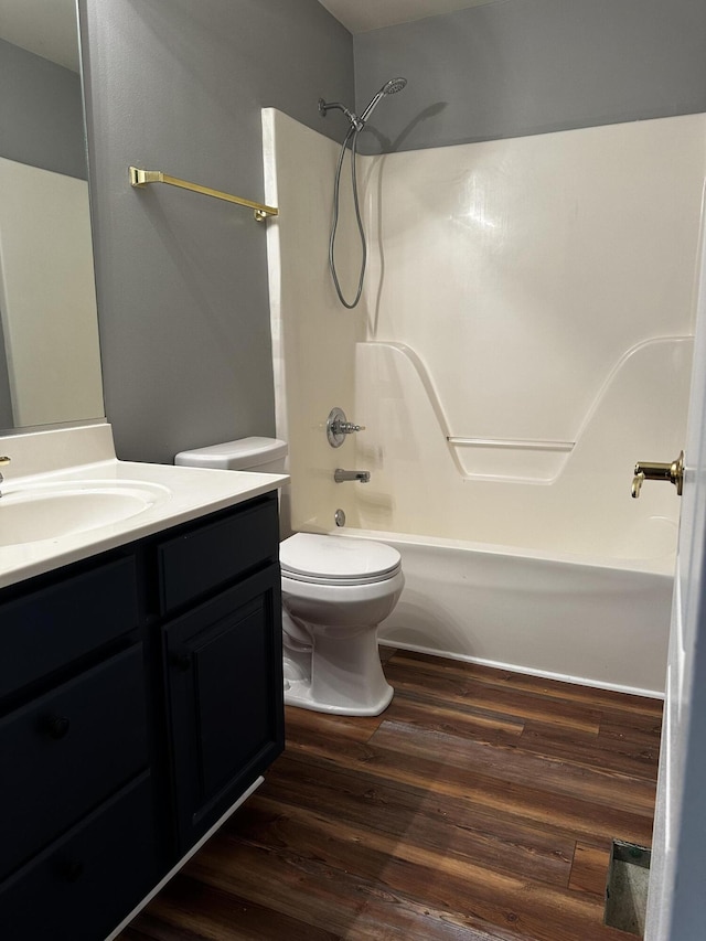 bathroom featuring toilet, vanity, shower / tub combination, and wood finished floors