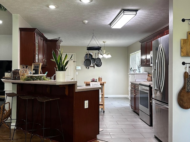76 Waterford Way, Somerset, KY 42501 - kitchen featuring appliances with stainless steel finishes, a kitchen breakfast bar, a peninsula, glass insert cabinets, and a textured ceiling