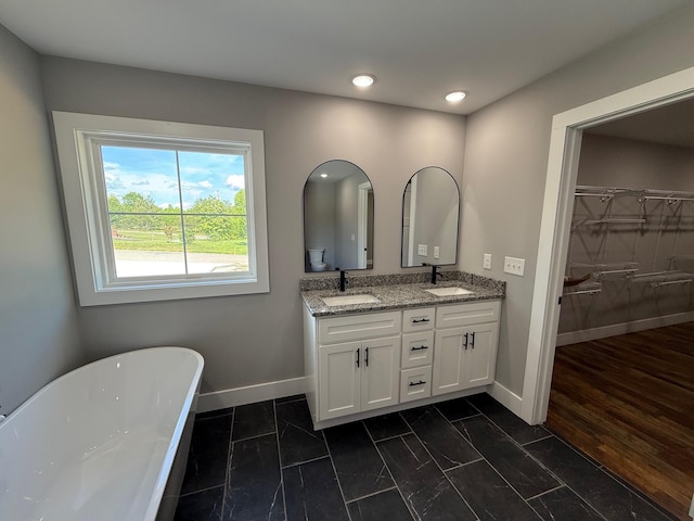 10 Nolan Dr, Corbin, KY 40701 - bathroom featuring double vanity, a freestanding tub, baseboards, a spacious closet, and recessed lighting