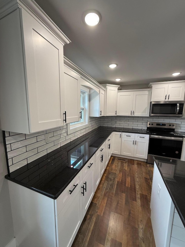 10 Nolan Dr, Corbin, KY 40701 - kitchen featuring appliances with stainless steel finishes, dark wood-style floors, tasteful backsplash, white cabinets, and recessed lighting