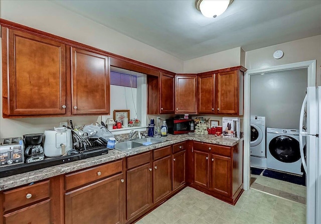 149 Willis Ave, Frankfort, KY 40601 - kitchen with independent washer and dryer, a sink, black microwave, freestanding refrigerator, and light stone countertops