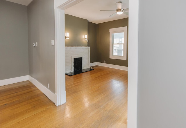 1010 Aurora Ave, Lexington, KY 40502 - unfurnished living room with light wood-style floors, a ceiling fan, baseboards, and a brick fireplace