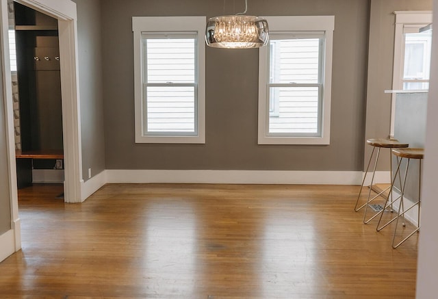 1010 Aurora Ave, Lexington, KY 40502 - unfurnished dining area with a chandelier, wood finished floors, and baseboards