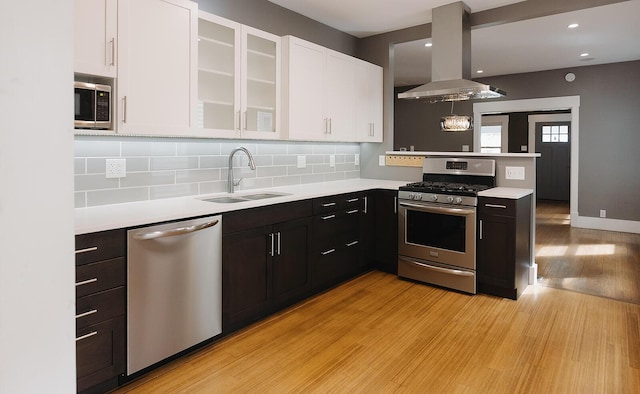 1010 Aurora Ave, Lexington, KY 40502 - kitchen featuring stainless steel appliances, a sink, island exhaust hood, white cabinets, and light countertops