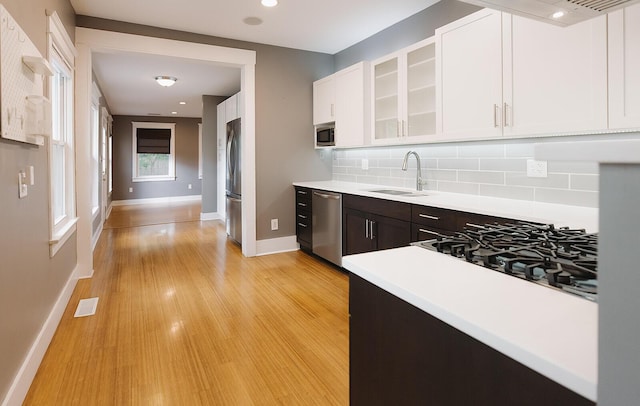 1010 Aurora Ave, Lexington, KY 40502 - kitchen featuring stainless steel appliances, a sink, light countertops, white cabinets, and tasteful backsplash