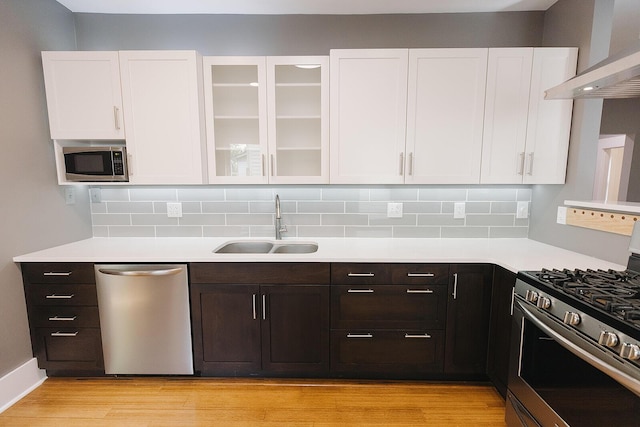 1010 Aurora Ave, Lexington, KY 40502 - kitchen featuring stainless steel appliances, wall chimney exhaust hood, a sink, and white cabinets