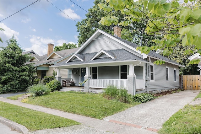 1010 Aurora Ave, Lexington, KY 40502 - view of front of house featuring a porch, a shingled roof, and a chimney