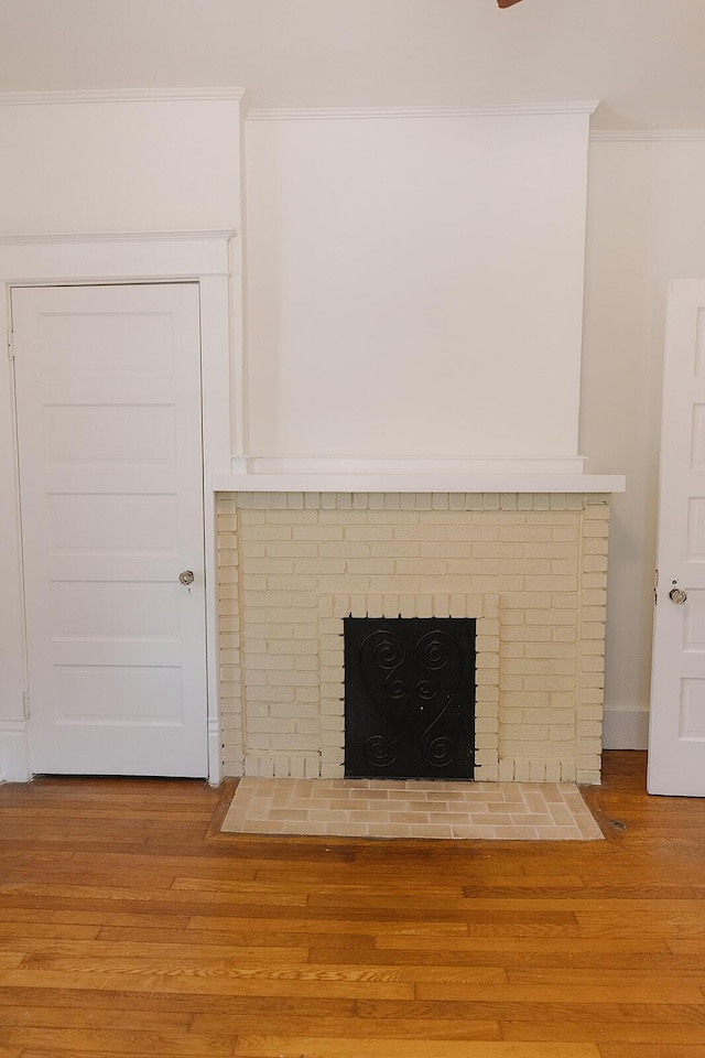 1010 Aurora Ave, Lexington, KY 40502 - detailed view of crown molding, wood finished floors, and a brick fireplace