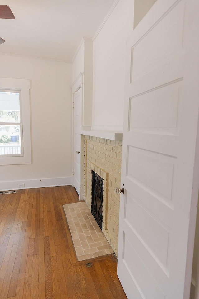 1010 Aurora Ave, Lexington, KY 40502 - unfurnished living room with wood-type flooring, a fireplace, crown molding, and baseboards