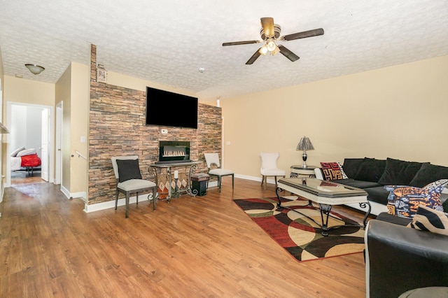 109 Rich Ln, Georgetown, KY 40324 - living room featuring wood finished floors, a textured ceiling, ceiling fan, baseboards, and a fireplace