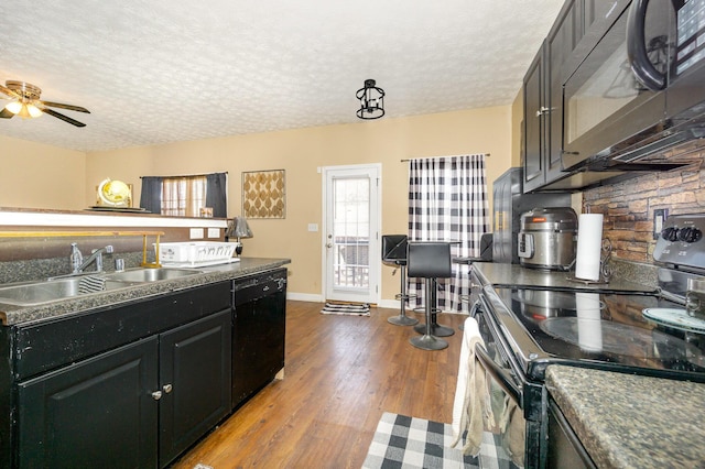 109 Rich Ln, Georgetown, KY 40324 - kitchen with black appliances, a sink, a textured ceiling, wood finished floors, and dark countertops