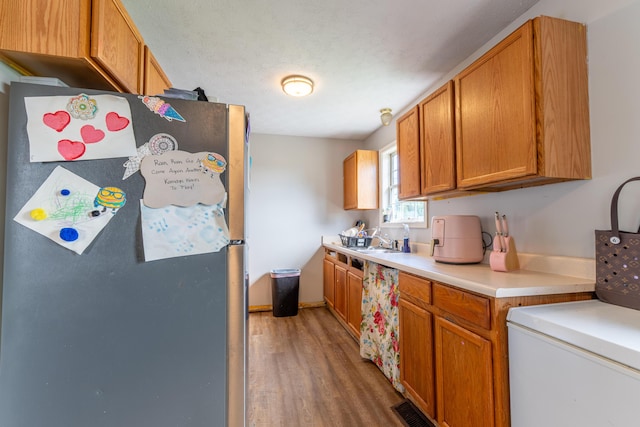 550 S Lucas St, Junction City, KY 40440 - kitchen with freestanding refrigerator, wood finished floors, light countertops, a sink, and brown cabinetry