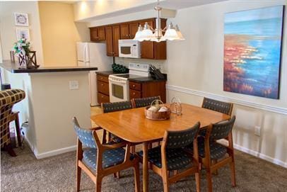 4218 Reserve Rd Unit 104, Lexington, KY 40514 - carpeted dining space with baseboards and a chandelier