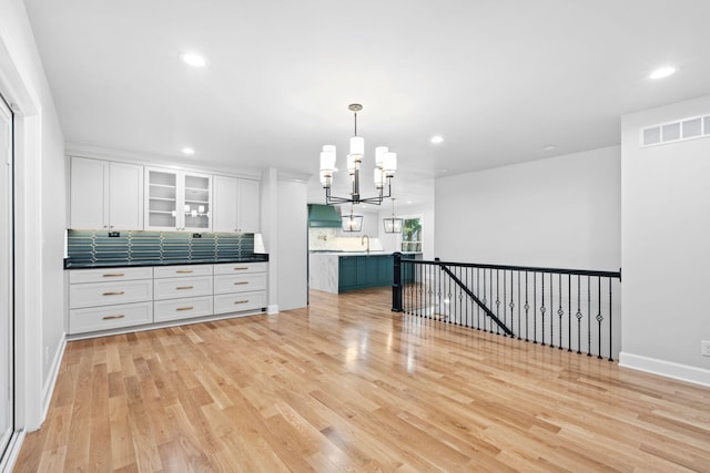 810 Cooper Dr, Lexington, KY 40502 - kitchen with a chandelier, white cabinetry, a sink, light wood finished floors, and tasteful backsplash