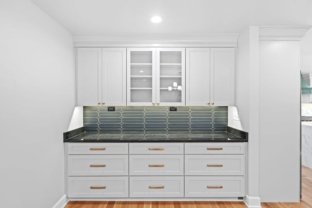 810 Cooper Dr, Lexington, KY 40502 - kitchen with white cabinetry, decorative backsplash, dark stone counters, glass insert cabinets, and light wood-style flooring
